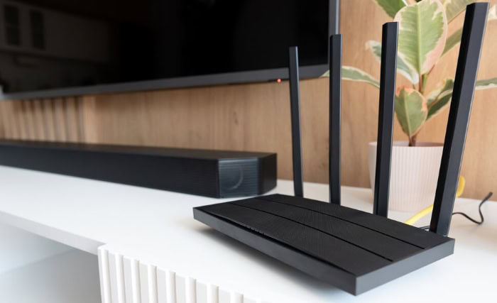 Black wireless router with antennas on media shelf