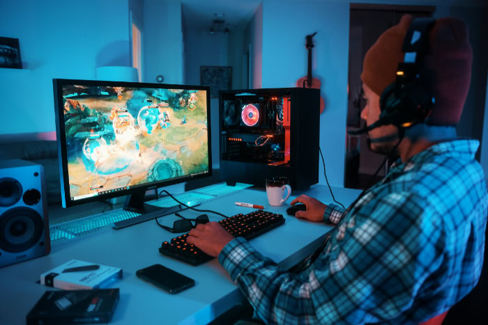 Gamer playing on desktop PC with monitor and headset