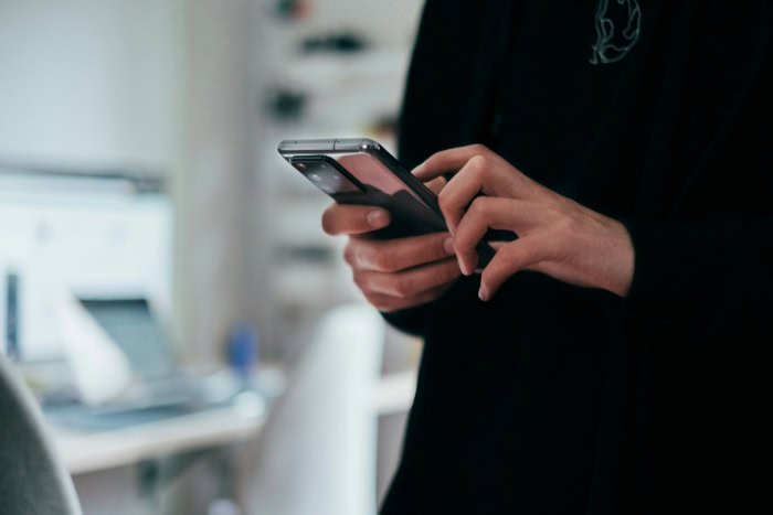Person using smartphone in modern home office