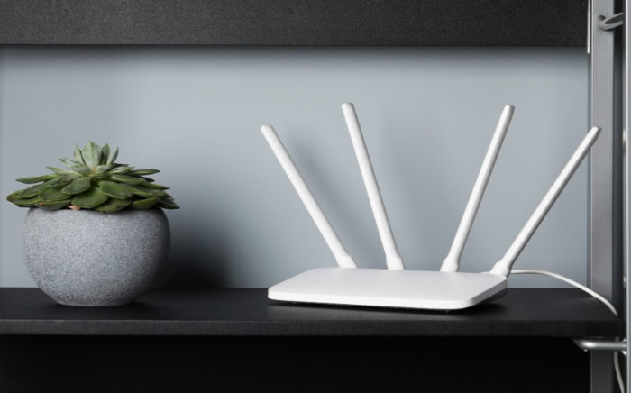 White WiFi router with four antennas and succulent